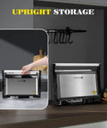 Aigostar 1200W Panini Press Sandwich Maker With Ceramic Non Stick Plates Opens 180 Degrees For Indoor Grilling Stainless Steel Removable Drip Tray Silver Compact Kitchen Appliance For Quick Meals in upright storage position.