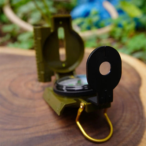 Close-up of Dope Outdoor Compass For Camping And Hiking Your Go To Orienteering Tool For Accurate Navigation Wilderness Survival And Adventure Folding Metal Cover And Floating Dial on wooden surface