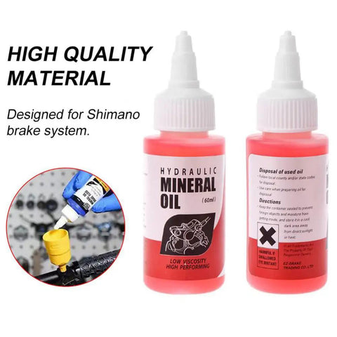 Two bottles of hydraulic mineral oil for Shimano brake systems with high quality label and usage instructions.