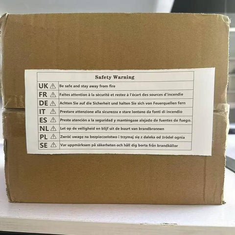 Cardboard box with multilingual safety warning label including English, French, German, Spanish, Dutch, Polish, and Swedish instructions.