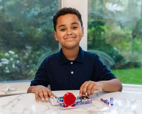 Child assembling Interactive FM Radio Kit For Kids 8 Plus Hands On STEM Electronics Project DIY Science Kit on a table