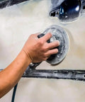Person using a 6 Inch Hook And Loop Sanding Disc with 15 Holes for dust extraction on a surface during sanding.