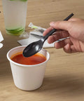 Six Point Five Inch Wrapped Compostable Spoons For Hot And Cold Food 250 Individually Wrapped Plant Based Black CPLA Disposable Utensils BPI Certified Eco Friendly Cutlery For Restaurants And Events black CPLA spoon over soup cup