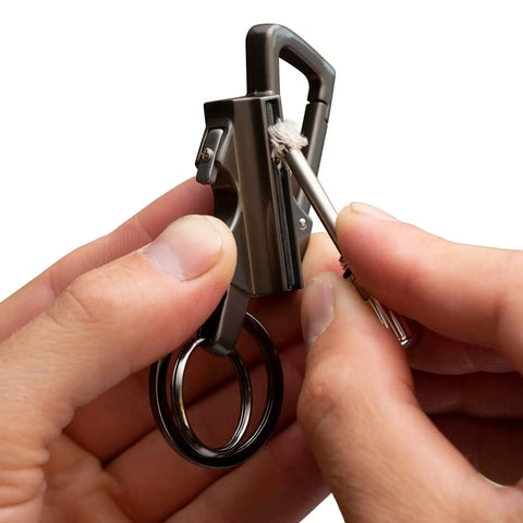 Hand holding Permanent Match Bottle Opener Keychain, Reusable Survival Fire Starter Striker Lighter in use.