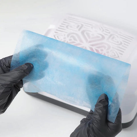 100Pcs Nail Dust Collector Filter Paper Replacement Pads disposable blue filter held by gloved hands over dust cleaner