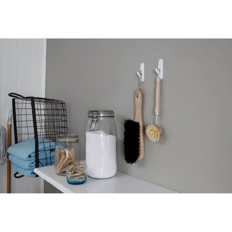 Two beige cleaning brushes hanging on wall using Large Utility Hook Mega Pack 14 Count For No Fuss Damage Free Hanging Holds Strong On Painted Walls
