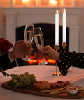 Couple toasting with champagne glasses near 36 Piece Flameless Taper Candles Set, 10 Inch Battery Operated LED Tapers