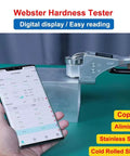 Handheld Digital Hardness Tester With Auto Storage And Quick Scale Switch For Steel Aluminum Brass Copper And Tough Metals Built Like A Tank For Daily Grind measuring metal block with digital display and smartphone.