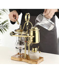 Top Shelf Siphon Coffee Maker Serving Up Smooth Brews And Chill Cold Steeps With Heavy Duty Glass And Classic Retro Styling Made For Any Casual Home Setup Without Mess Or Hassle, with gold accents and glass components.