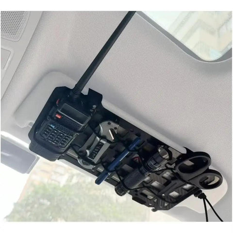 Rugged Tactical Sun Visor Rack With Reinforced Panels And Secure Lash Bands For Tesla Cybertruck holding tools and a radio.