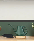 Tempered Steel Hand Trowel With Wood Handle 13 Inch Garden Tool on wooden surface next to plants and watering can.