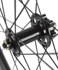 Close-up of the hub and spokes on Carbon Disc Wheelset 50C-23 Clincher Road Wheel Six Bolt Rotor 12x100 Thru Axle Built For Speed.