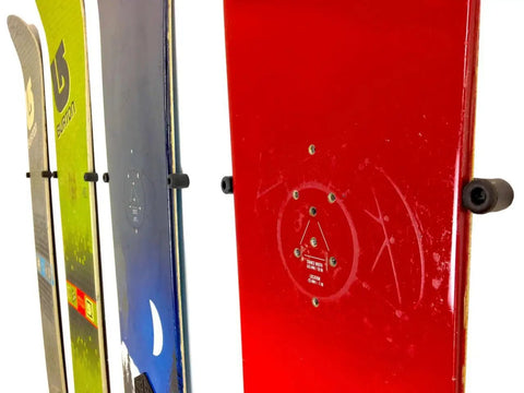 Minimalist Snowboard Wall Mount Display Rack Featuring Felt Padded Arms And Durable Rubber Grip To Stash Your Sick Ride Securely In Garage Or Home Studio And Recreation Room. Image of multiple mounted snowboards showing rubber grips.
