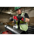 Hella Tough 18 Volt Brushless Cordless Drill And Driver used on a large steel pipe, operated by contractor wearing gloves.