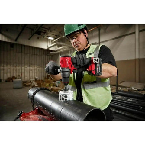 Hella Tough 18 Volt Brushless Cordless Drill And Driver used on a large steel pipe, operated by contractor wearing gloves.