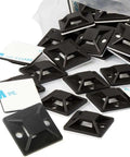 Pile of black cable tie mounts with adhesive backing next to open bag for indoor cable management