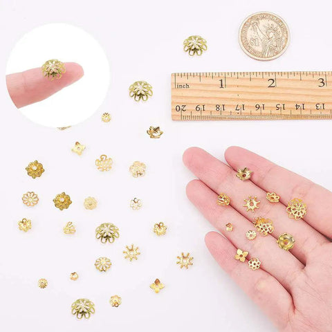 Golden Filigree Flower Bead Caps Set With 240 Pcs 12 Unique Brass Petal Ends for DIY jewelry making shown with a ruler and hand
