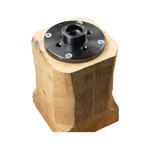 Rock Solid 4 Inch Wood Lathe Faceplate Made From Dang Tough Steel With A Rust Proof Black Finish And Eight Screw Holes mounted on rough wood.