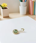 Pack Of 4 Self Adhesive Wall Hooks Featuring A Vintage Diamond Design in green on table with stationery and plants.