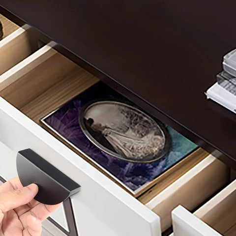 Hand holding Four Pack Half Moon Cabinet Pulls 2.5 Inch Semicircle Drawer Handle in black aluminum over open drawer