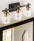 Three Light Industrial Bathroom Vanity Sconce with Black Gold Finish above mirror, clear glass shade, modern farmhouse style