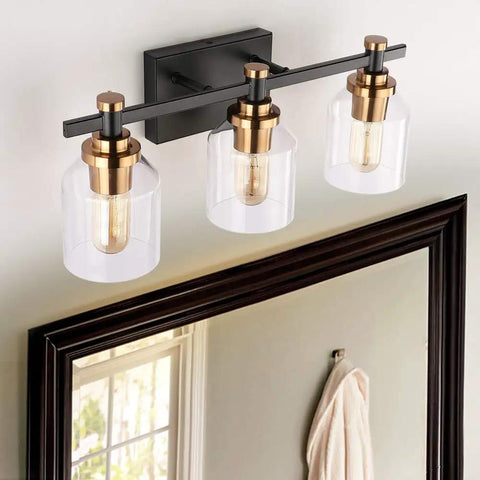 Three Light Industrial Bathroom Vanity Sconce with Black Gold Finish above mirror, clear glass shade, modern farmhouse style