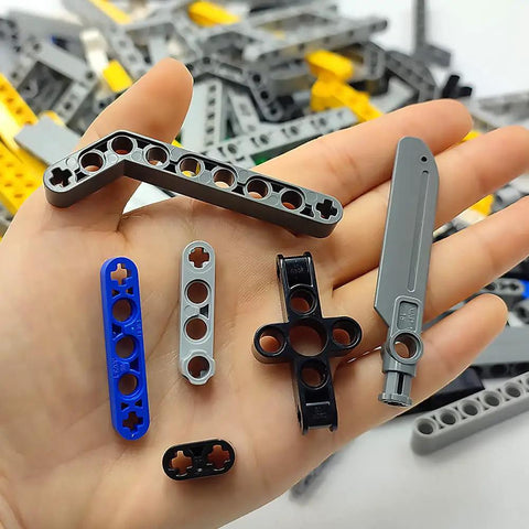 Hand holding parts from Beam Set With 266 Pieces For STEM Engineering And Car Building Projects Includes Chassis Frames Liftarms