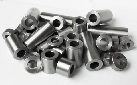 Front view of steel spacers: round, unthreaded cylindrical bushings with through-holes in silver finish.