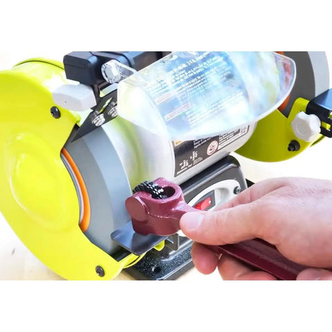 Hand using a wrench on Heavy Duty 10 Piece Wheel Dresser Replacement Blades with electric grinder for precision sharpening.