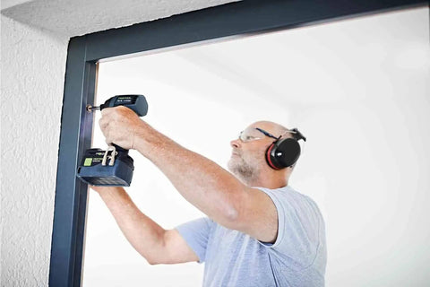 Person using Kickass Cordless Impact Drill And Driver With Brushless EC-TEC Motor 18V System for mounting screws.