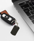 Top Shelf Gold Plated Aluminum Keychain Featuring Fresh Ribbon Grid Design Compact Rectangle Shape Rustproof Everyday Carry Daily Essential For Women And Men attached to key fob and resting by a laptop.