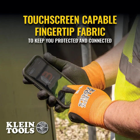 Person wearing orange and black touchscreen-friendly gloves using a smartphone. Klein Tools branding visible.