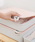 Hand reaching for lid of Pink Plastic Underwear Storage Box With Marked Lid For Under Bed Closet Drawer Organization Hella Tough Polypropylene Bin.