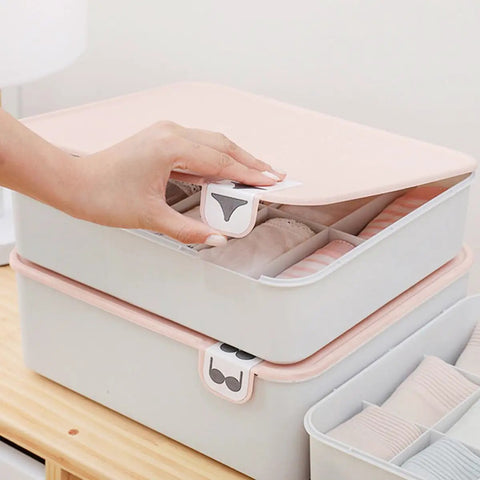 Hand reaching for lid of Pink Plastic Underwear Storage Box With Marked Lid For Under Bed Closet Drawer Organization Hella Tough Polypropylene Bin.