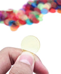 Hand holding a yellow chip from the 1000 Transparent 3/4 Inch Bingo Counting Chips in Eight Color Set for Bingo Games