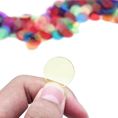 Hand holding a yellow chip from the 1000 Transparent 3/4 Inch Bingo Counting Chips in Eight Color Set for Bingo Games