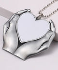 Sublimation Angel Wing Ornament Blanks Set With Metal Love Heart Pendant held by silver tone hands.