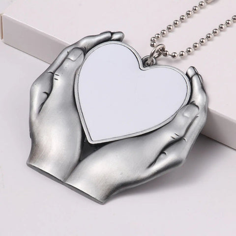Sublimation Angel Wing Ornament Blanks Set With Metal Love Heart Pendant held by silver tone hands.