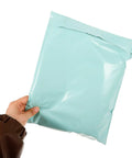 Hand holding Eco Friendly Polyethylene Clothing Shipping Bags With Strong Self Sealing Waterproof And Wear Resistant Mailers 50 Pack