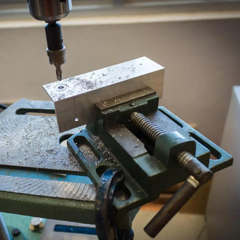 Tough As Nails Six Inch Milling Vise Heavy Duty Cast Iron Bench Clamp Precision Guiding Bar One Eighty Degree Turn Handle For Drill Press securing aluminum block during drilling.