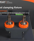 Tool clamping fixture with two CNC tool holders on gray base, orange rings visible in machining center.