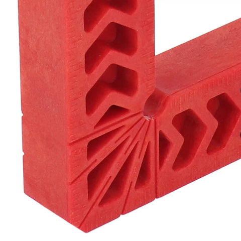 Close-up of a red heavy duty plastic corner clamp from a 12 Pack Heavy Duty Plastic Corner Clamps For Woodworking Right Angle Frame Assembly Jig With Badass Non Slip Grip For DIY Furniture And Cabinetry No Sweat Setup Every Time.