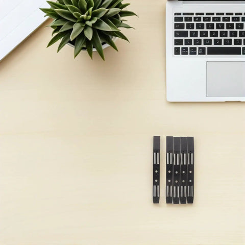 No Sweat Screwless 3.5 Inch Hard Drive Caddy Rails Five Pairs laid out on a desk with a laptop and plant.