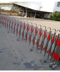 Built Different Stainless Steel Retractable Crowd Control Fence With Fast Roll Wheels Heavy Duty on pavement in long line.