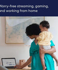 Woman holding child while working on laptop, showcasing WiFi Mesh Extender For Eero 6 To Extend Coverage Up To 1500 Sq Ft With WiFi 6 speeds