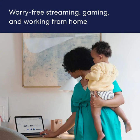 Woman holding child while working on laptop, showcasing WiFi Mesh Extender For Eero 6 To Extend Coverage Up To 1500 Sq Ft With WiFi 6 speeds