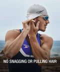 Swimmer adjusting Go-To Unisex Silicone Swim Cap For Adults, no-snag, stretchy, hair-friendly, durable, latex-free, at the beach.