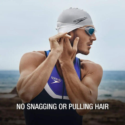 Swimmer adjusting Go-To Unisex Silicone Swim Cap For Adults, no-snag, stretchy, hair-friendly, durable, latex-free, at the beach.