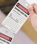 "Danger barricade tag in hand, Safety Tags by the Roll Caution Barricade OSHA Compliant Tags Waterproof PF Cardstock resists tears."