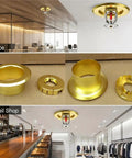 Top Shelf Fire Sprinkler Escutcheon Covers 3 4 Inch Removable Head Plates in gold finish installed in office and retail settings.